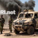 Somali soldiers stand guard near a destroyed Al-Shabaab vehicle, smoke rising in the background.